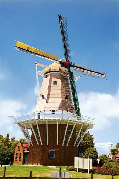 Traditional Dutch windmill in Foxton, New Zealand, under a blue sky, featured as a must-see stop on an Auckland to Wellington road trip.